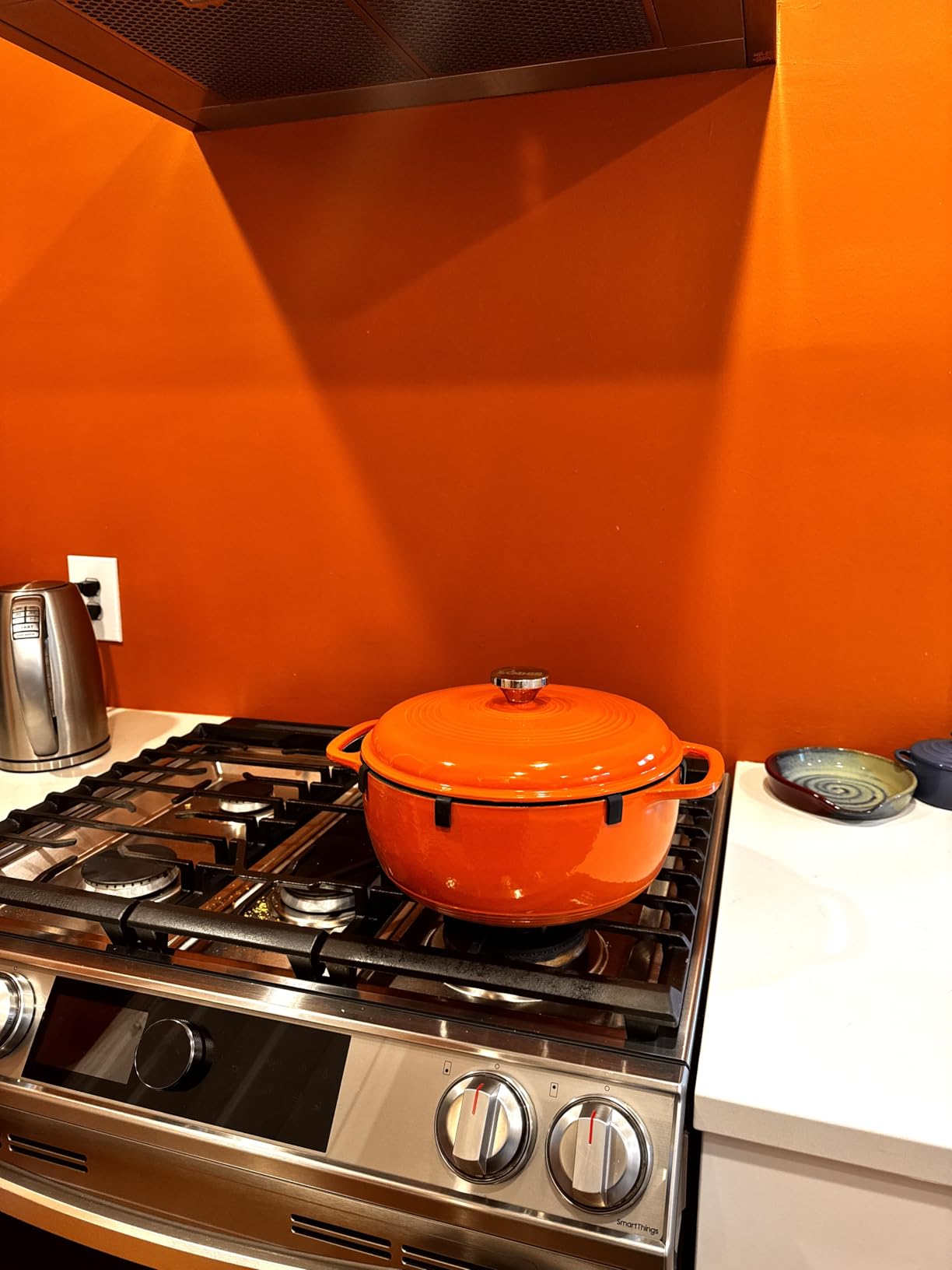 Customer photo showing the Lodge Dutch Oven in Poppy color on kitchen range